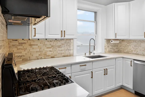 a kitchen with sink a stove and cabinets