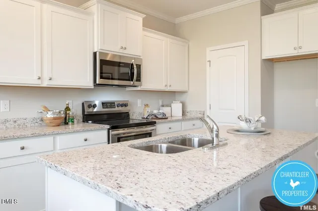 a kitchen with granite countertop a sink a stove and microwave with cabinets