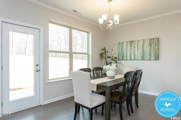 a dining room with furniture a potted plant and a chandelier