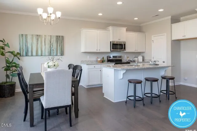 a view of kitchen with cabinets dining table and chairs