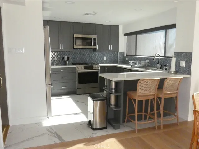 a kitchen with stainless steel appliances a sink stove and refrigerator
