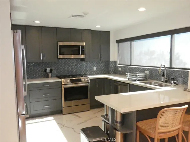a kitchen with a stove a sink and a refrigerator