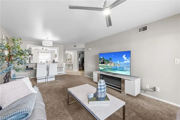 a living room with furniture a rug and white walls