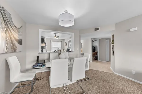 a living room with furniture a mirror and white walls