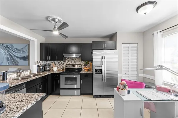 a kitchen with stainless steel appliances kitchen island granite countertop a refrigerator and stove