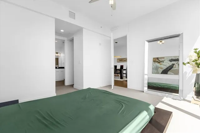 a living room with a bed furniture and a view of bedroom