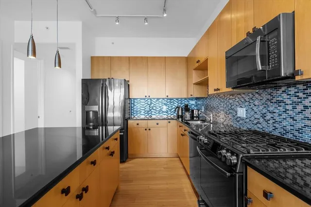a kitchen with granite countertop a stove and a refrigerator