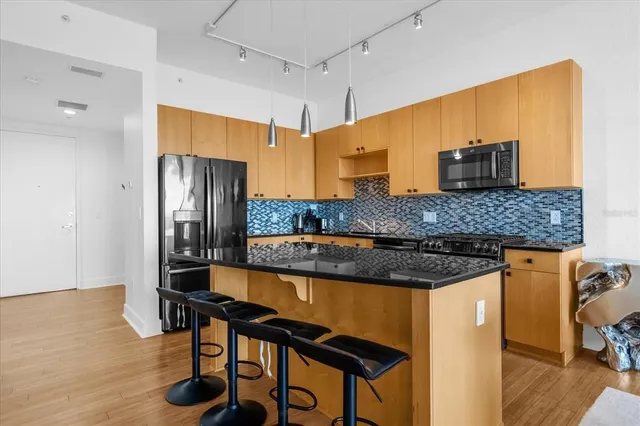 a kitchen with stainless steel appliances granite countertop a sink and refrigerator