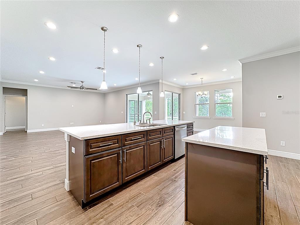 19424 Oakleaf Street Orlando, FL 32833 - Photo 11 of 43 a kitchen with kitchen island a counter top space a sink stainless steel appliances and cabinets
