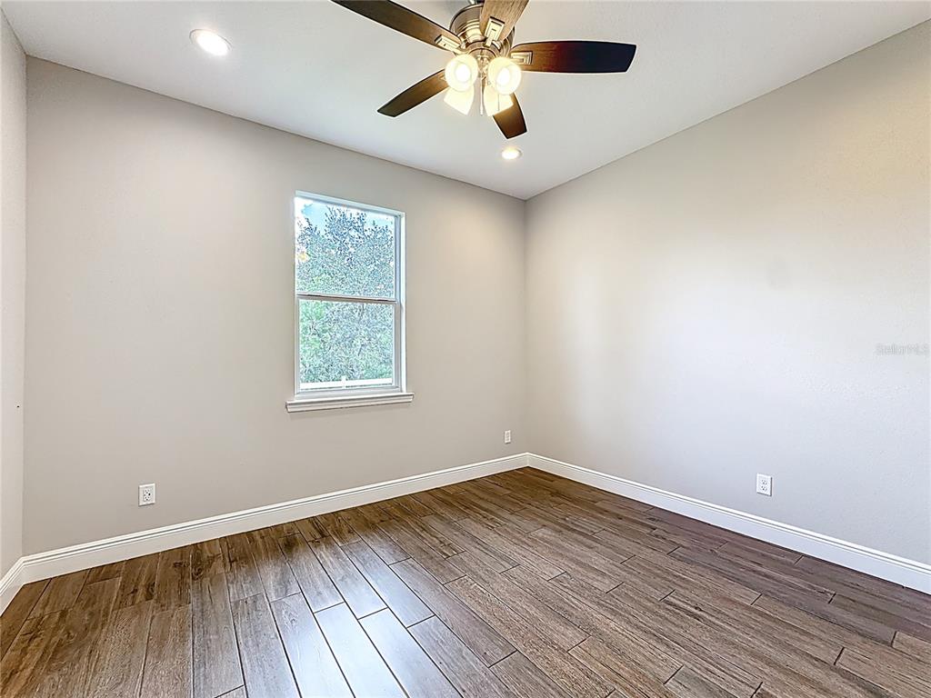 19424 Oakleaf Street Orlando, FL 32833 - Photo 22 of 43 an empty room with a window and wooden floor