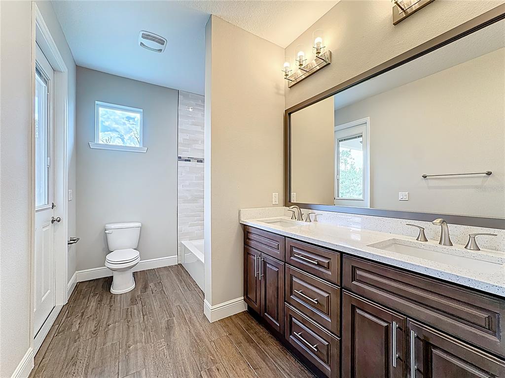 19424 Oakleaf Street Orlando, FL 32833 - Photo 23 of 43 a bathroom with a granite countertop sink a toilet and a mirror