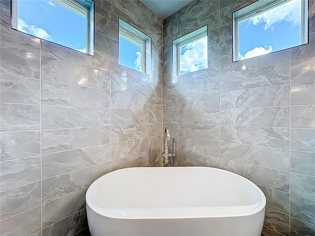 19424 Oakleaf Street Orlando, FL 32833 - Photo 32 of 43 a white bath tub sitting in a bathroom