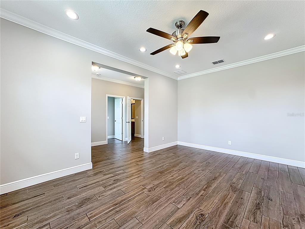 19424 Oakleaf Street Orlando, FL 32833 - Photo 6 of 43 an empty room with wooden floor and a ceiling fan