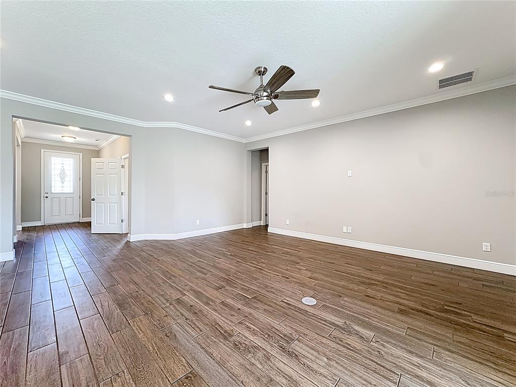 19424 Oakleaf Street Orlando, FL 32833 - Photo 9 of 43 a view of a room with wooden floor and a ceiling fan