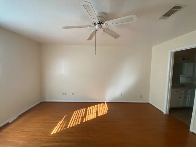 an empty room with a ceiling fan and closet area