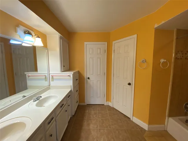 a spacious bathroom with a double vanity sink and a mirror