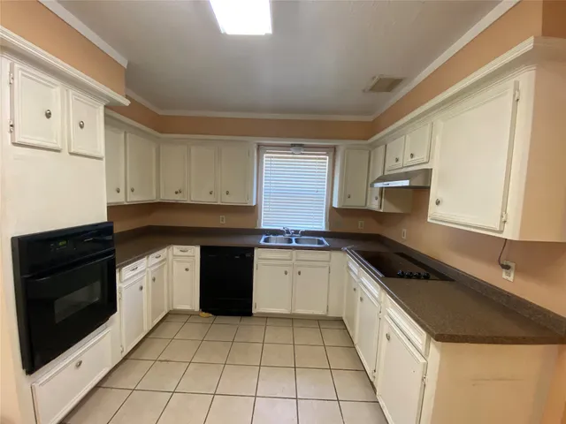 a kitchen with a sink dishwasher stove and cabinets