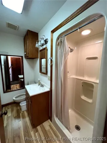 a bathroom with a shower a mirror and a sink