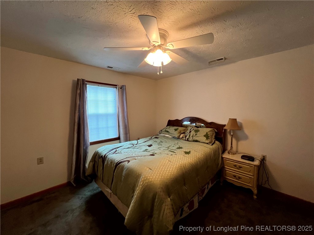 2472-2 John Hall Road Fayetteville, NC 28312 - Photo 8 of 10 a bedroom with a bed and a chandelier