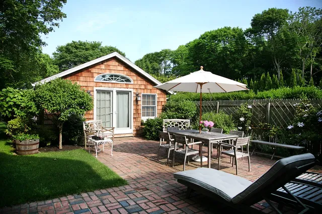 a view of a house with backyard sitting area and garden