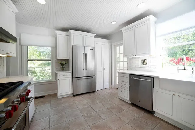 a kitchen with a refrigerator sink and cabinets