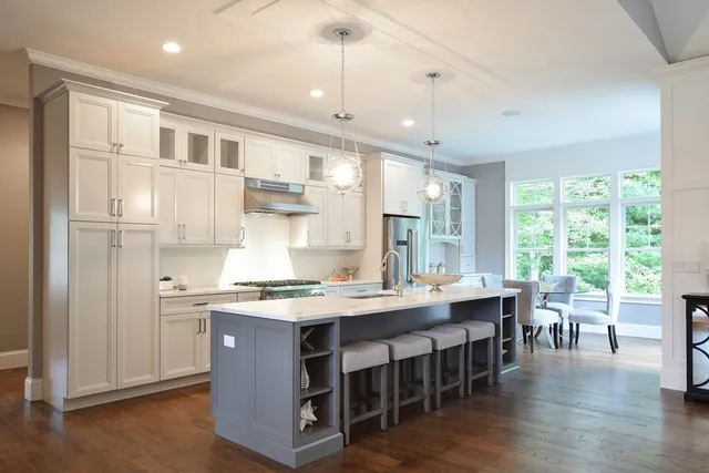 a large kitchen with kitchen island a dining table chairs and wooden floor
