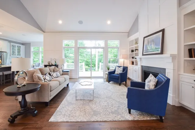a living room with fireplace furniture and a large window