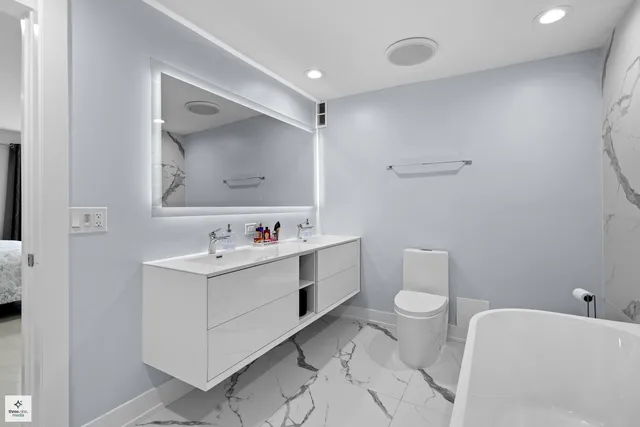 a bathroom with a sink mirror vanity and toilet