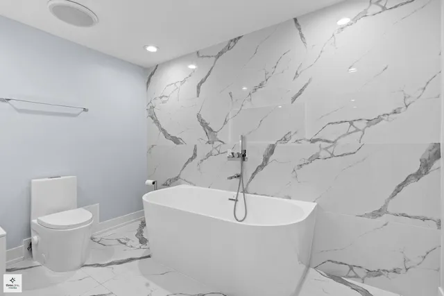 a white bath tub sitting next to a white toilet