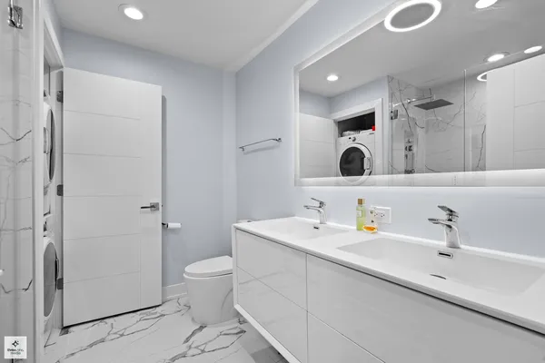 a bathroom with a double vanity sink mirror and toilet