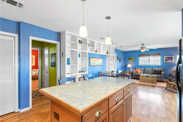 a kitchen with stainless steel appliances granite countertop a refrigerator a stove top oven a sink dishwasher and white cabinets with wooden floor