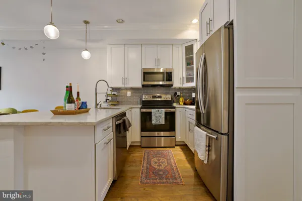 a kitchen with kitchen island a counter top space stainless steel appliances and cabinets