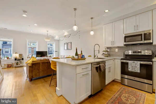 a kitchen with kitchen island granite countertop a sink cabinets and stainless steel appliances