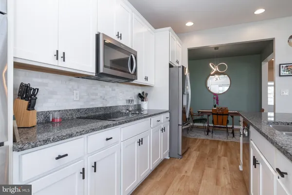 a kitchen with granite countertop a sink stove and cabinets