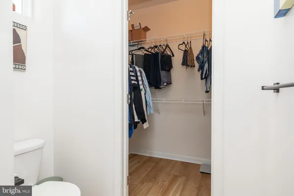 a view of walk in closet with clothes and shoes