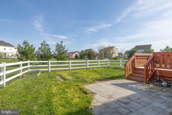 a view of a patio with table and chairs with wooden floor and fence