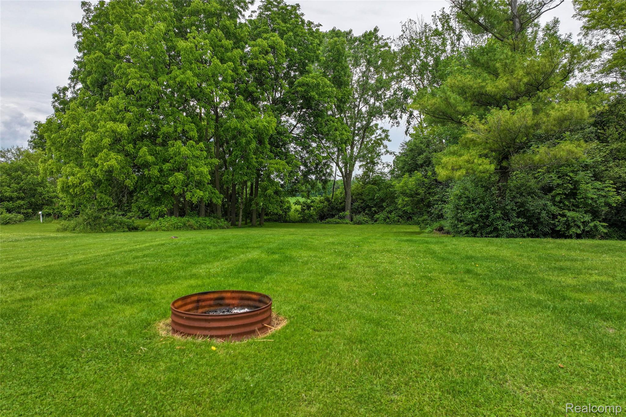 1336 West Hurd Road Clio, MI 48420 - Photo 8 of 43 Expansive green lawn with a built-in metal fire pit