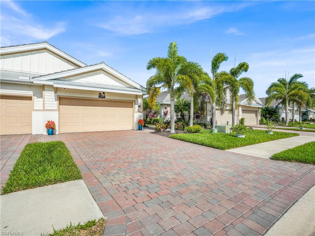 14695 Edgewater Circle Naples, FL 34114 - Photo 3 of 39 a front view of a house with garden