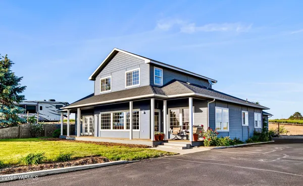 a front view of a house with swimming pool and porch with furniture