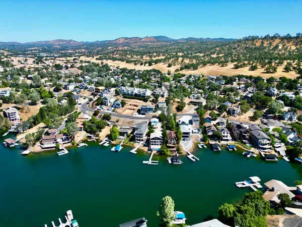 an aerial view of residential houses with outdoor space and trees