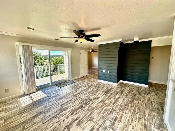 a view of a livingroom with a ceiling fan and wooden floor