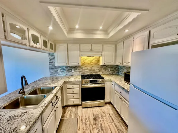 a kitchen with stainless steel appliances granite countertop a sink stove and refrigerator