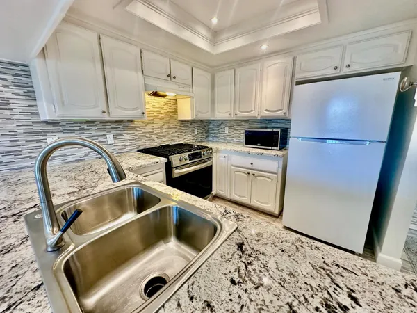 a kitchen with a refrigerator sink and cabinets