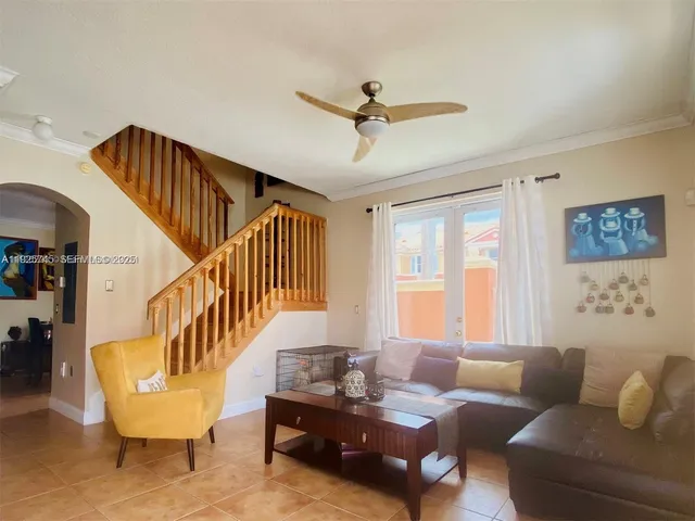 a living room with couches and a dining table with wooden floor