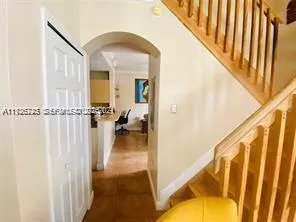 a view of a hallway with a couch and dining room view