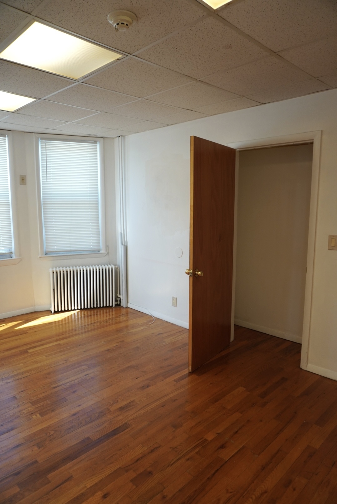441 Castleton Avenue, Unit 2 Staten Island, NY 10301 - Photo 3 of 10 an empty room with wooden floor and windows