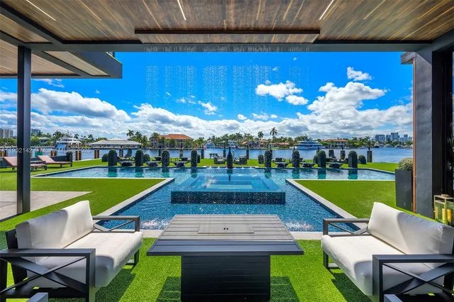 a living room with furniture a flat screen tv and a floor to ceiling window