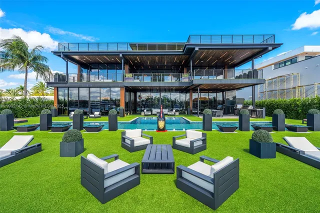 a living room with furniture a chandelier and a floor to ceiling window