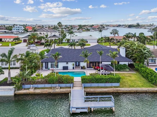 an aerial view of residential houses with outdoor space and lake view in back