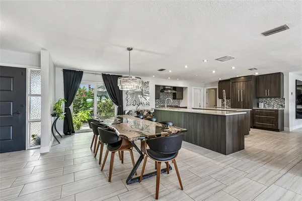 a kitchen with kitchen island granite countertop a refrigerator and a stove top oven